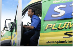 A person in a blue shirt steps out of a Steve's Plumbing van on a sunny day.