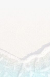 Waves gently washing onto a sandy beach, creating a foamy edge where the water meets the shore.
